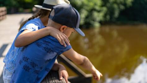 poika ja tyttö katselemassa sillalta Siuntion jokea.