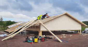 Två byggnadsarbetare bygger ett tak.