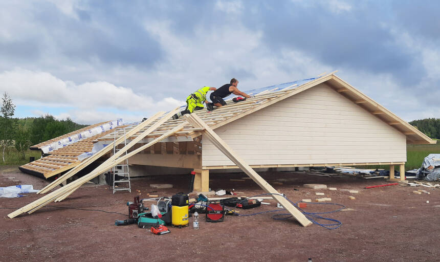 Två byggnadsarbetare bygger ett tak.