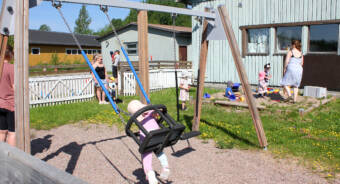 Småbarn och föräldrar i en lekpark.