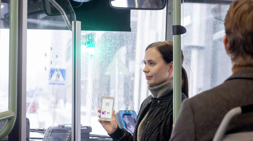 En ung kvinna var sin biljett på en mobiltelefon i en buss.